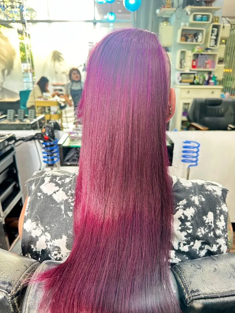 Long straight hair coloured pink and magenta, photographed in the salon