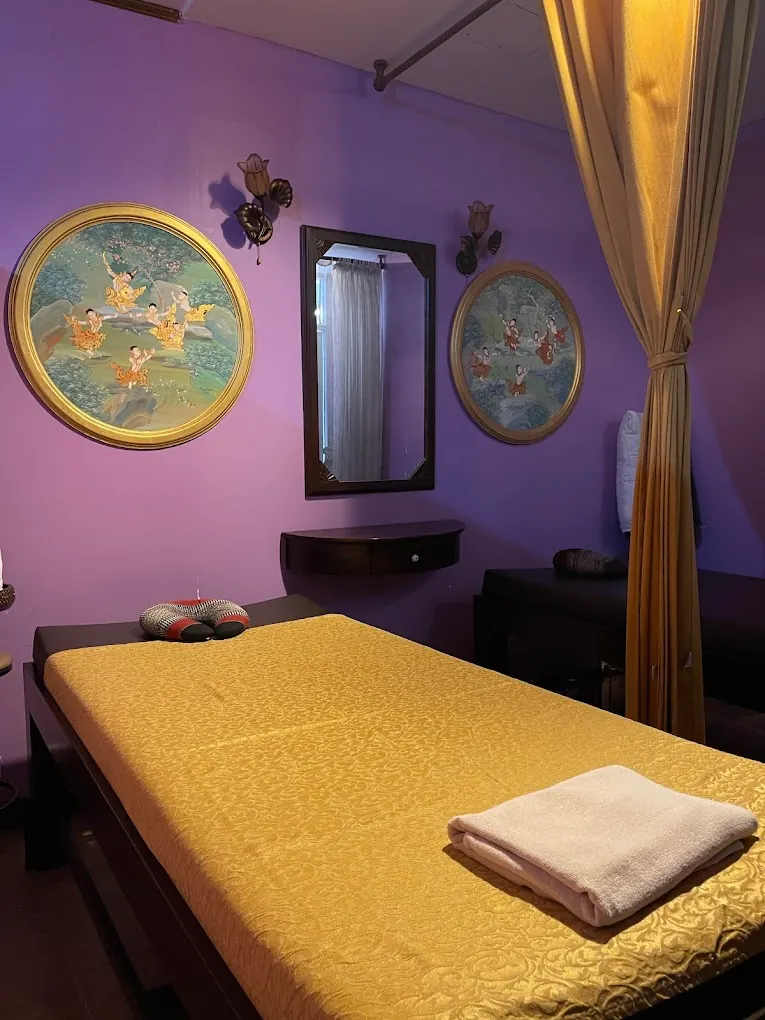 Massage room with a Thai massage bed and traditional Thai paintings