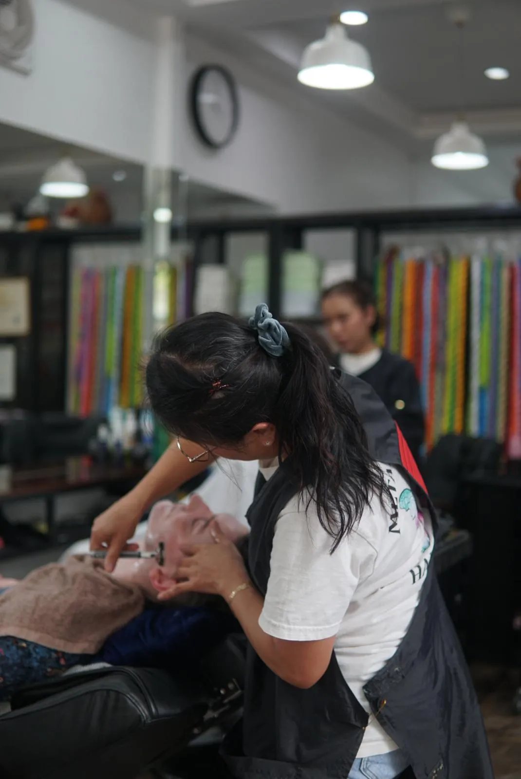 Stylist giving a customer a straight-razor shave in the salon